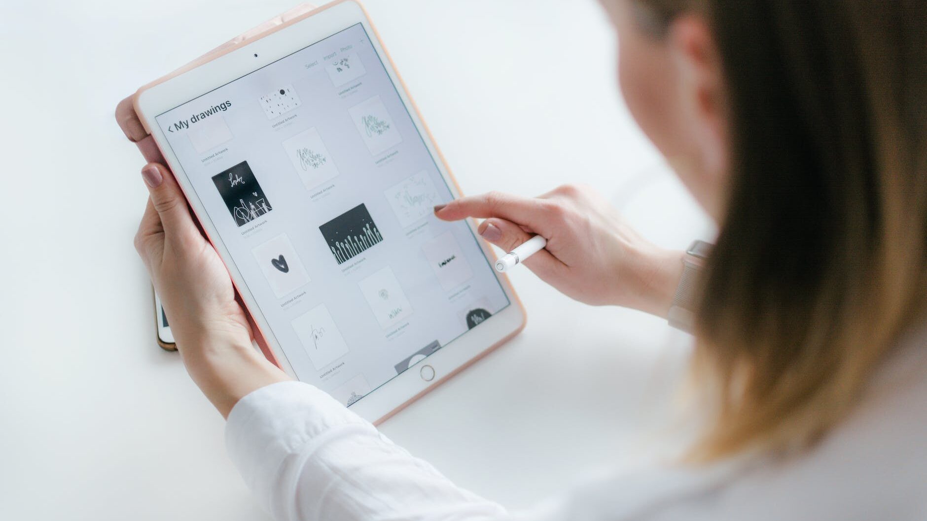 woman sitting beside table while using ipad