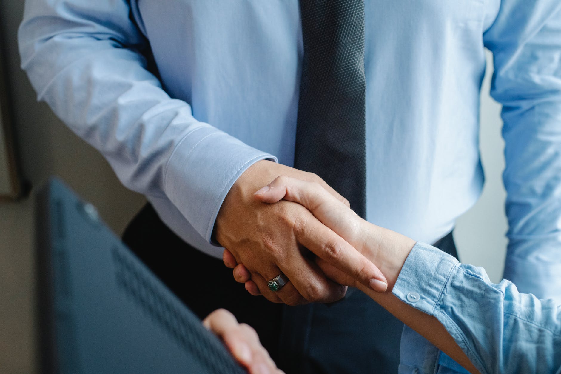 anonymous colleagues shaking hands before business meeting