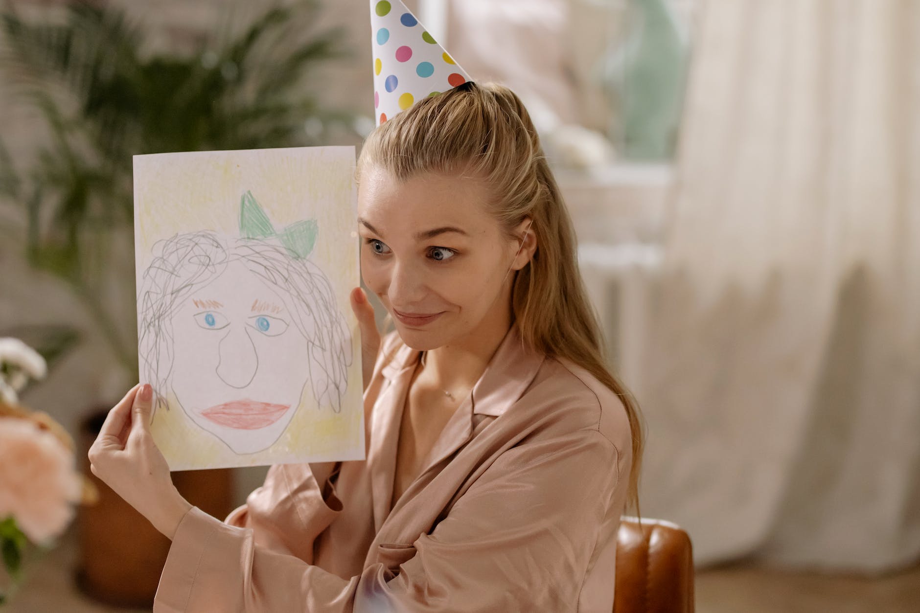 a woman holding a drawing beside her face