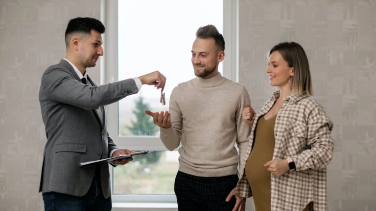 a real estate agent handing the key to the new homeowners