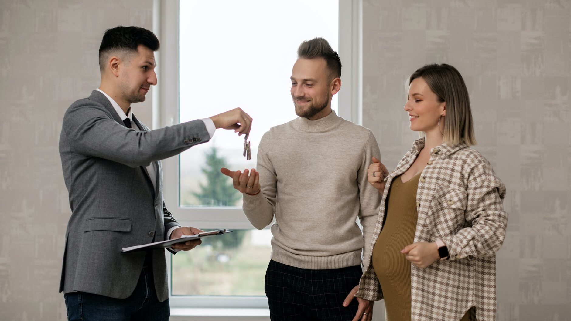 a real estate agent handing the key to the new homeowners