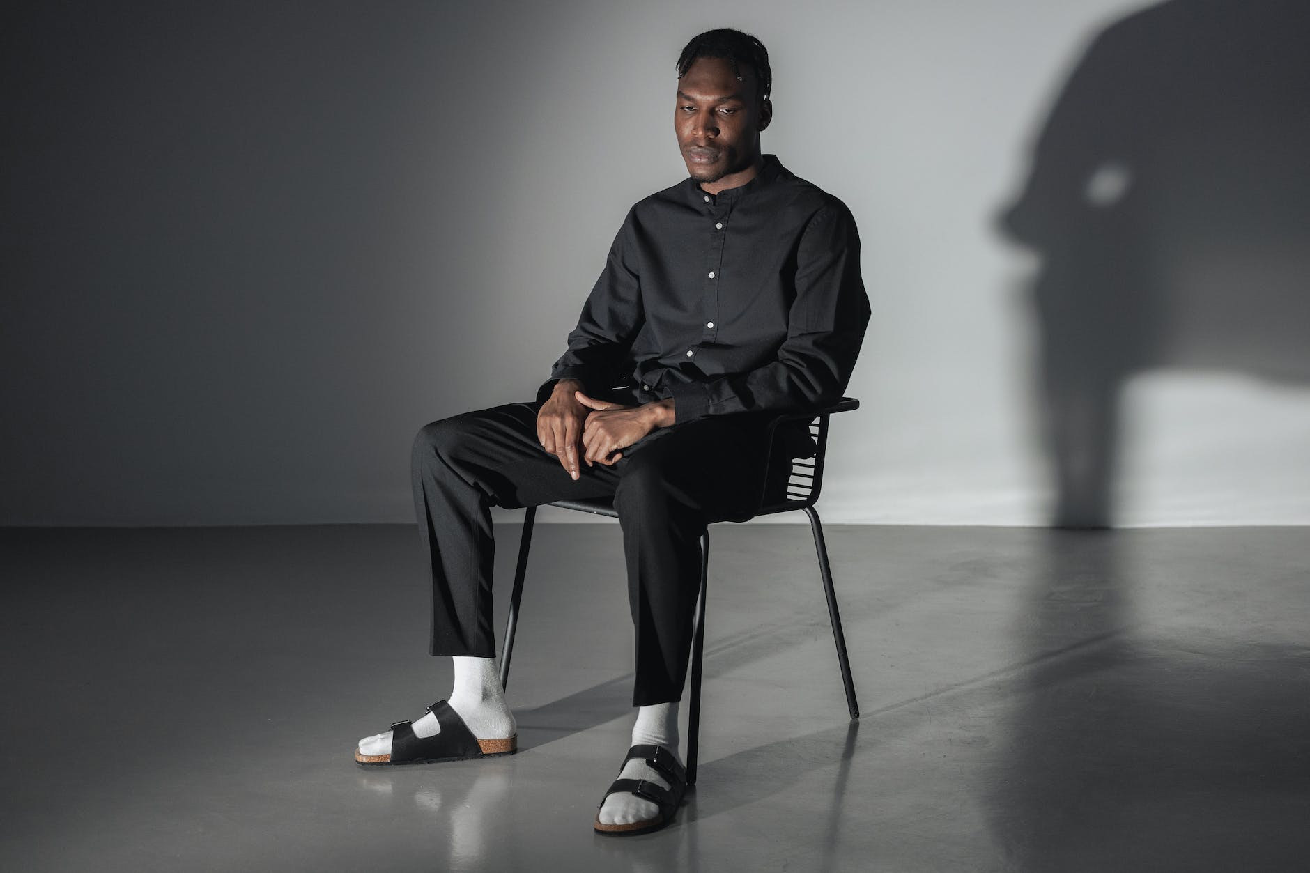 man in black button up shirt sitting on black chair